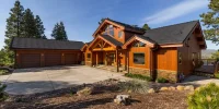 Timber frame custom home with natural wood siding, exposed beam entry, stone accents, three-car garage, and mountain landscaping at Ridgewater Properties in Klamath Falls, Oregon