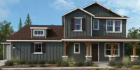 Two-story craftsman-style custom home with dark gray board-and-batten siding, timber porch columns, stone accents, and a brown shingle roof at Ridgewater Properties in Klamath Falls, Oregon